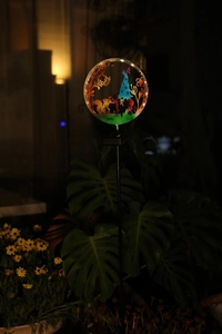 Detailed close-up of solar garden light featuring a glowing gnome and squirrel scene