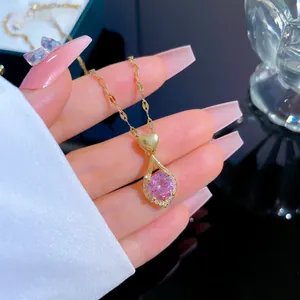 Détail du collier cœur doré avec grosse pierre rose et cristaux micro-pavés brillants
