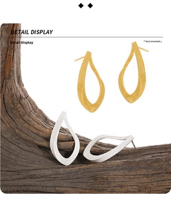 Detail view of hollow teardrop earrings with brushed gold and silver metal textures