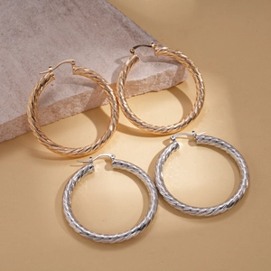 Minimalist geometric spiral hoop earrings in polished gold and silver metal finishes