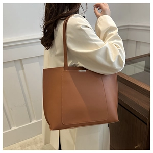 Brown PU leather tote bag shown on model highlighting spacious capacity and minimalist style