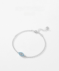 Detailed close-up of a silver Evil Eye bracelet with blue beads and a heart charm