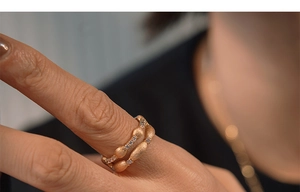 Close-up of stacked rose gold rings with brushed texture and micro-set white zircon stones