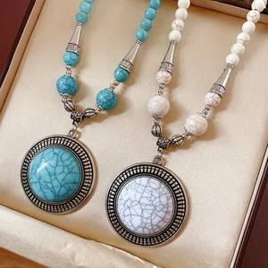 Detail view of retro ethnic stone necklaces with green and white marble round pendants