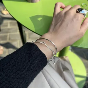 Detail of S925 sterling silver minimalist geometric bracelet and ring set on model
