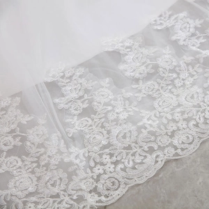 Elegant white lace off-shoulder wedding dress with intricate floral embroidery and long train