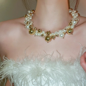 Close-up of French chunky pearl necklace with oversized white pearls and gold metal beads