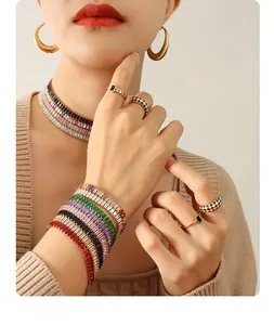 Close-up of stacked vintage-style gold jewelry set with colorful zirconia and enamel