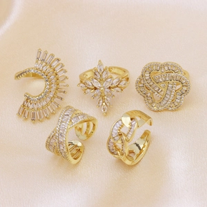 Five-piece set of gold-plated rings and ear cuffs with clear cubic zirconia on silk fabric