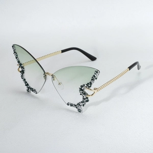 Exaggerated butterfly rhinestone sunglasses with gradient green lenses and rimless design.
