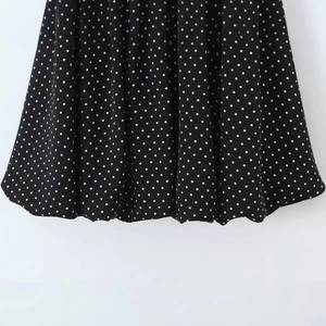 Stylish black and white polka dot summer dress with feminine flutter sleeves and ruffled hem