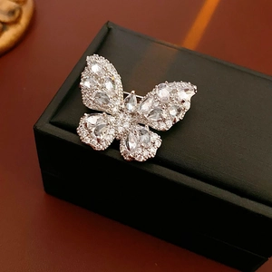 Macro shot of butterfly brooch with pear-cut cubic zirconia on a black texture box