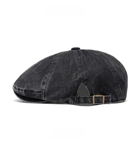 Side view of washed denim newsboy cap showing metal buckle and fine stitching details