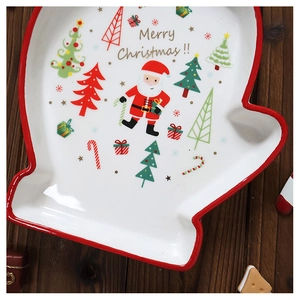 Macro detail of glove-shaped ceramic Christmas plate with Santa Claus and tree patterns