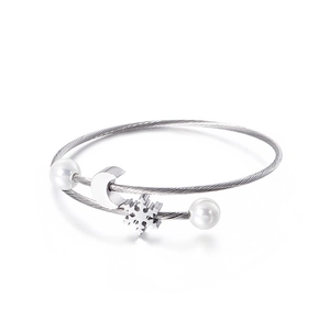 Silver stainless steel moon and snowflake bangle with white pearls on a white background