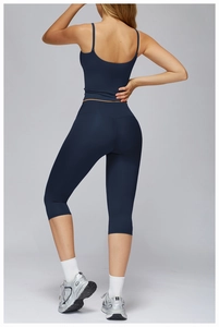 Rear view of navy blue yoga set featuring a thin strap sports bra and high-waisted capri leggings