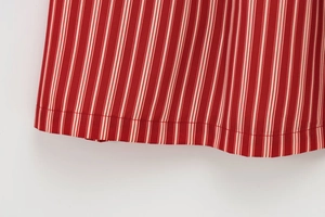 Detailed close-up of red and white striped fabric with high-density stitching at the hem