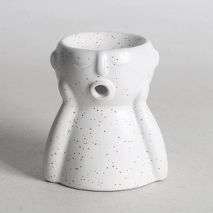 Macro detail of abstract ceramic wax burner with speckled finish and artistic bust design