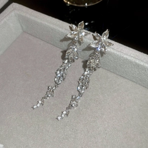 Close-up of elegant flower tassel earrings with sparkling crystals on velvet box
