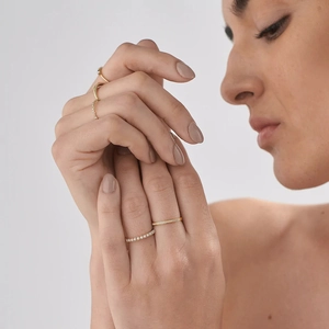 Close-up of elegant gold stackable rings with small pearls and tiny pavé diamonds