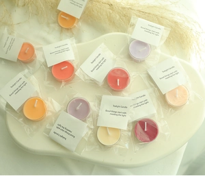 Colorful scented tealight candles in assorted colors arranged on a white artistic tray