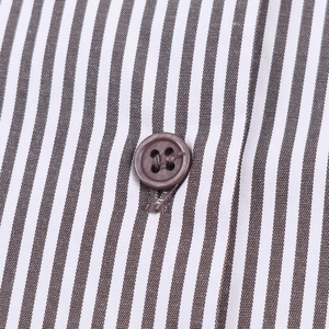 Close-up of brown striped fabric with a matching four-hole button on the sleeve