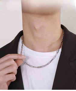 Model wearing a minimalist silver paperclip chain necklace with a rectangular design