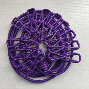 Close-up of purple windproof clips on a retractable elastic travel clothesline cord