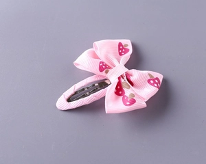 Close-up of pink ribbon hair clip with white polka dots and sweet strawberry pattern
