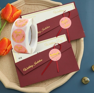 Pink Thank You stickers with gold leaf design on a wedding envelope with tulips