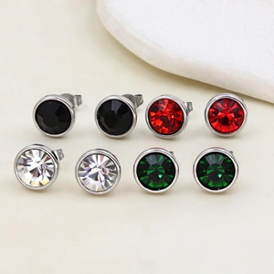 Macro view of four pairs of round zirconia stud earrings in black, red, white and green