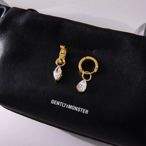 Elegant gold titanium steel teardrop zircon earrings on black leather display
