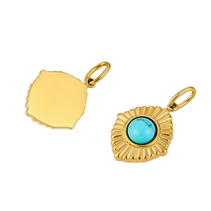 Detail view of gold-plated sunburst pendant featuring turquoise stone and textured metal
