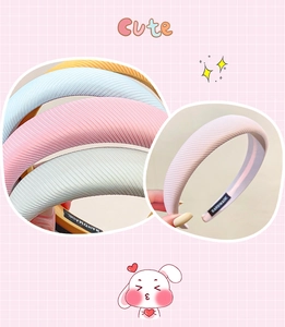 Detailed view of thick ribbed fabric headbands in pastel colors with handmade labels
