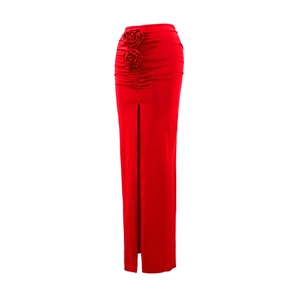 Detail of red slim fit skirt featuring side ruching and 3D floral accents with a high slit