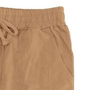 Detail of camel linen pants showing elastic waistband with drawstring and side pocket