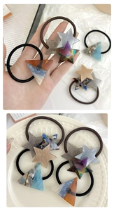 Close-up of acrylic star and triangle hair ties in tortoiseshell and marble patterns