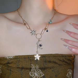 Détail du collier doré avec pendentifs lune et étoile sertis de strass sur le mannequin