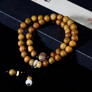Macro shot of double-loop green sandalwood beads with glossy texture in a gift box