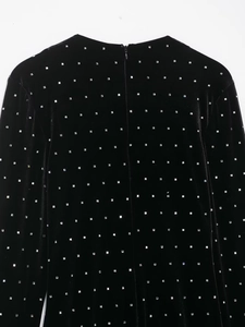 Detailansicht eines schwarzen Samt-Midikleids mit silbernen Pailletten und Reißverschluss