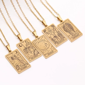 Detailed close-up of gold tarot card pendants including The Hermit and The Moon