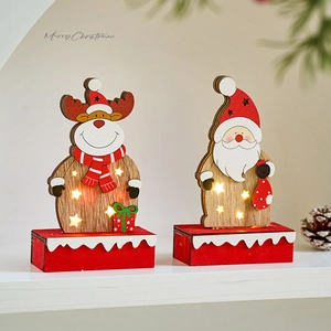 Christmas wooden reindeer and Santa LED ornaments with warm lights on a snowy base