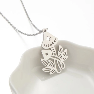 Silver mushroom necklace with hollow leaf and moon pendant on white ceramic plate