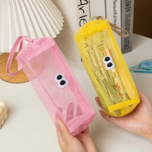 Detail of cute mesh pencil bags with cartoon eyes, side handles in pink and yellow