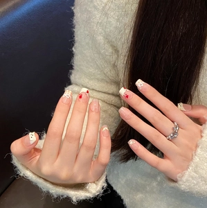 Cartoon cat paw press-on nails with red hearts and plaid pattern on hand with ring