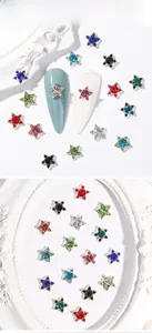 Detail of colorful star-shaped nail charms with gold metal frames and vibrant rhinestones