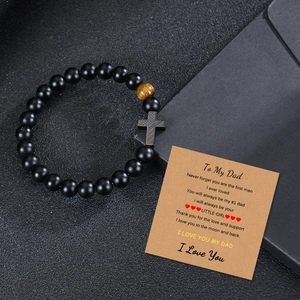 Men's black beaded bracelet with cross and tiger eye stone on a gift message card