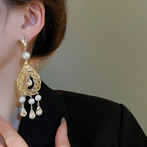 Detail of vintage French gold earrings with pearls and water drop crystals on model