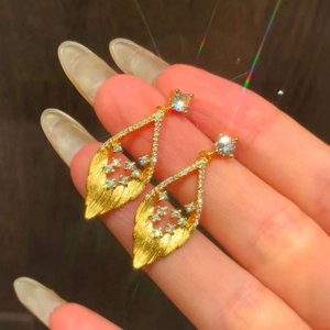 Boucles d'oreilles pendantes dorées avec cristaux étincelants au design de feuille