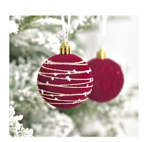 Detail of burgundy velvet Christmas ball with gold glitter lines and silver stars